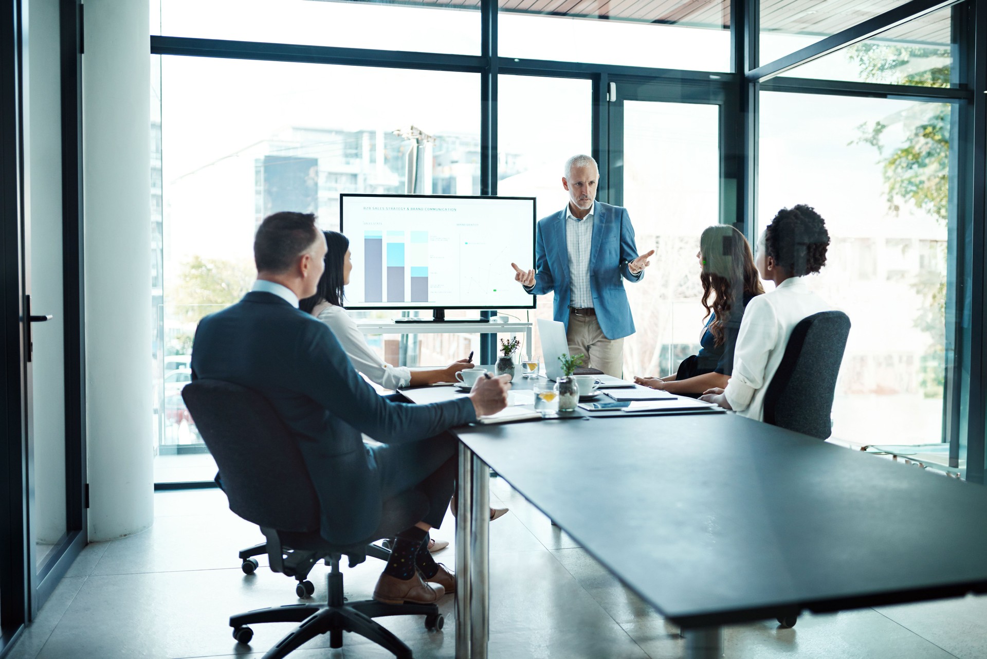 Manager, leader and boss talking to his team or group of colleagues in a presentation, seminar or workshop in a boardroom meeting. Discussing strategy, the company mission and vision for the future